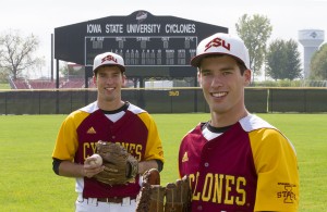 Adam and Austin Fichter are dressed in thier ISU club baseball uniforms and stand on the baseball field with ball and gloves in hand