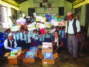 Children in a classroom in Nepal hold up books donated by the Asia Foundation