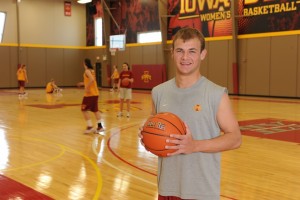 B.J. Brugman poses with a basketball on a court during an Iowa State Women's Basketball practice.
