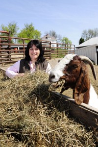 Bonnie Hoffmann with her goat by a bed of hay.