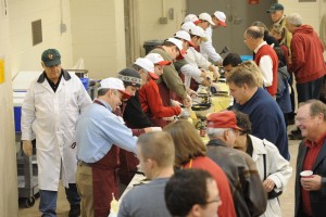 Animal science departmental staff stand in a long line preparing omlets for guests at the annual Chuckwagon Breakfast in Kildee Pavillion.