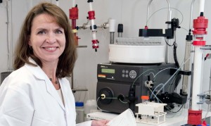 Elizabeth Longeran sits in a lab coat by a machine