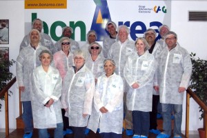 A group wearing sanitary gowns poses for a group photo before touring a meat processing plant in Spain.