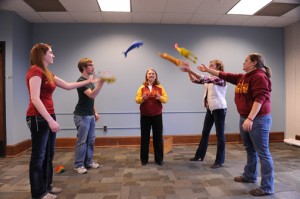Four students toss rubber turkeys back and forth as a communication and leadership exercise put on by Beth Foreman