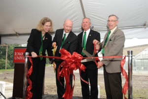 President Geoffrey, Dean Wintersteen, Jeff Iles, and Dwight Hughes cut a red ribbon to reveal the new greenhouse