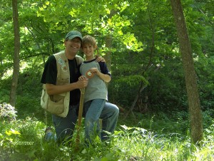 Iowa State alum Paul Tauke poses with his Son while on a hike in a forest