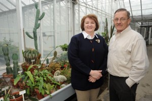 Arlene and Carol Patrick stand in front of cacti plants in the Iowa State Greenhouse.