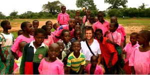 Sean Lundy poses for a picture with a group of kids from Uganda