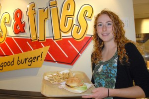 Lauren Mitchel holds a tray with a burger and fries on it