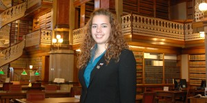 Headshot of Kristin Liska (junior) at the Iowa Statehouse with books, desks, and intricate architecture in the background