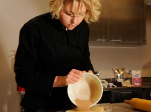 Kristy McCarthy pours cinnamon sugar onto freshly rolled-out dough
