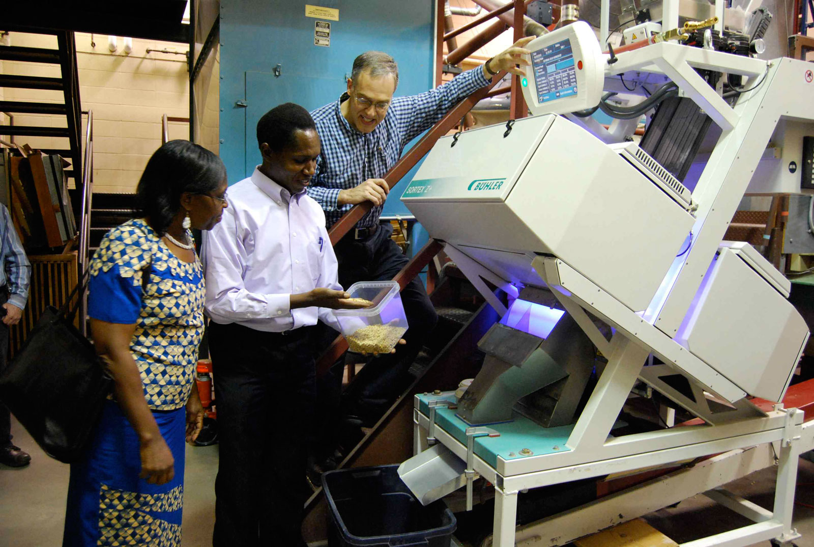 Alan Gaul demonstrates a color sorter machine to Professors of University of Nairobi