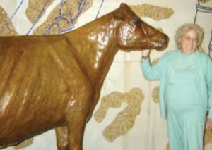 Norma "Duffy" Lyon stands next to the life-sized Iowa State Fair Butter Cow that she sculpted.