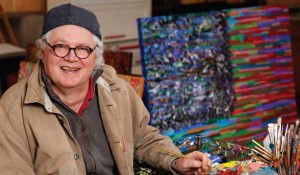Steve Nissen smiles while doing oil paintings