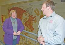 Jodi Sterle stands with student in Kildee Hall in front of mural