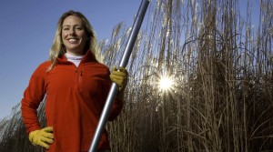 Emily Heaton stands next to field of perennial grasses