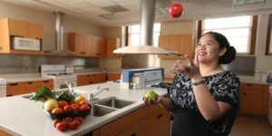 Mica Magtoto prepares fruits and vegetables in kitchen