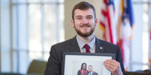 Dakota Olson holds a picture of him and Michelle Obama from when he served on her personal communications team