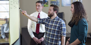 Steven Brockshus (center) discusses next step for his business with Kevin Kimle (left) and Mikayla Sullivan.