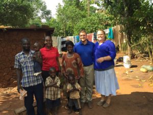 Megan Johnson, American Sign Language interpreter, and Kody Olson gather with Ugandan family on a study abroad