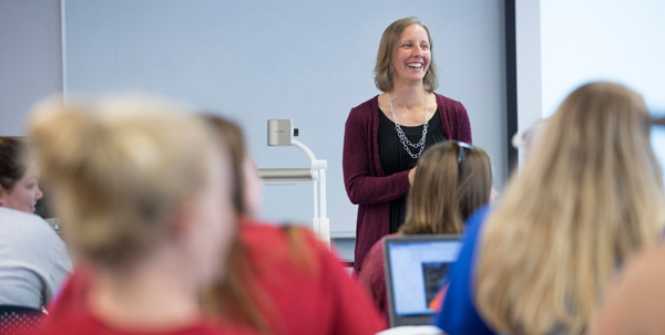 Amy Brandau stands at the front of the classroom teaching transfer students degree audits