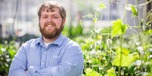 Headshot of Hunter Hamilton with plants in the background