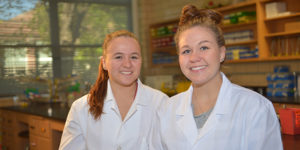 Sisters Ashley and Kenzie are pictured in a lab wearing lab coats
