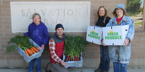 John Krzton-Presson horticulture and local foods coordinator with ISU Extension and Outreach, and volunteers Susan Townsend, Peggy Fey and Carolyn Burk drop off fresh produce to the Salvation Army weekly. The pose with boxes of carrotts they are delivering to the Salvation Army.