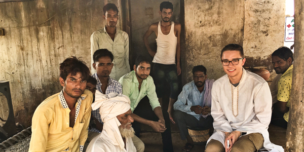 undergraduate poses sitting with Indian farmers