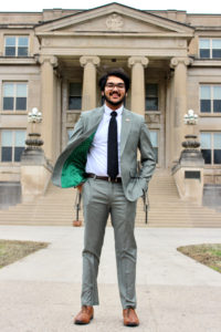 student wearing suit and tie in front of curtiss hall