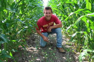 Mitchell Hora, kneeling between two rows of corn